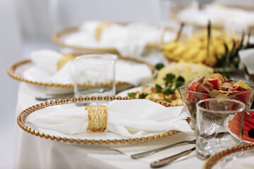a table with a tablecloth, a beautiful serving of white dishes, a beautiful plate, dinner in a restaurant
