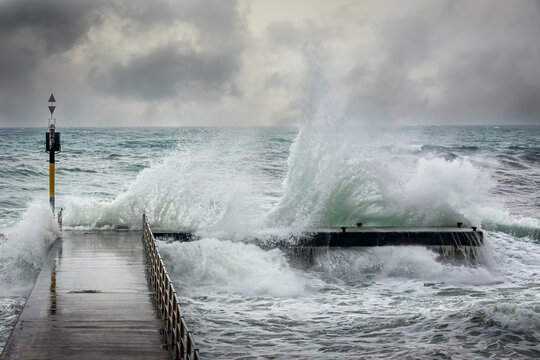 Stormy ocean waves splashing over a pier durring a winters storm