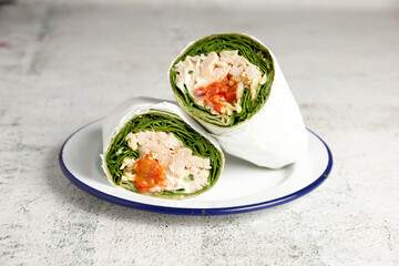 Chicken and lettuce wrap served on a plate in cafe