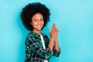 Photo of funny player lady hold fingers pistol shape have fun wear checkered shirt isolated teal color background