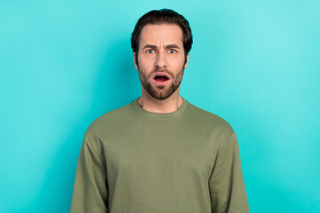 Fototapeta premium Photo of stressed brunet millennial guy open mouth wear green pullover isolated on teal color background
