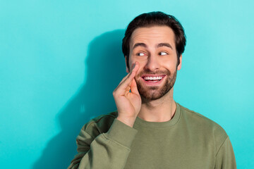 Photo of impressed beard millennial guy say secret wear khaki sweatshirt isolated on teal color...