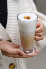 Woman hand with glass of latte coffee , close-up