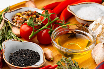 Oil, herbs and spices on wooden background
