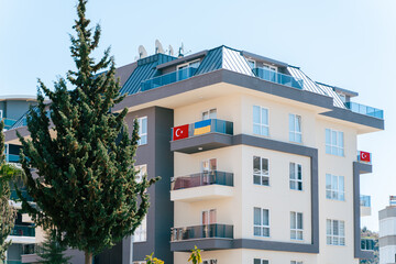 Fototapeta na wymiar Ukraine and Turkey national flags hanging from residential building balcony. Stand with Ukraine, stop war. Ukrainian community abroad. international support concept.