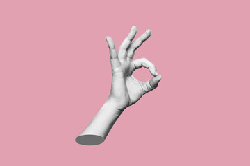 The female hand showing the ok gesture isolated on a pink color background. Trendy abstact 3d collage in magazine urban style. Contemporary art. Modern design. Okey hand sign
