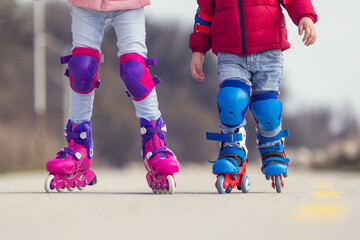 Kids boy and girl having fun outdoor while riding roller skates. Children on rollerblades. Roller...