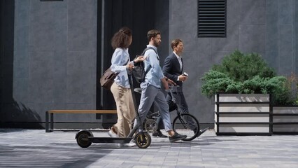 Two colleagues going downtown street talking. Shared eco-friendly transportation - Powered by Adobe