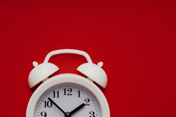 Part of white alarm clock on a red background. Deadline, reminder or concept of moment