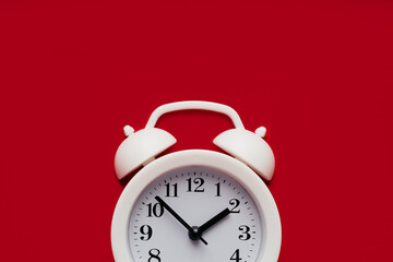 Part of white alarm clock on a red background close-up with copy space. Deadline, reminder or concept of moment