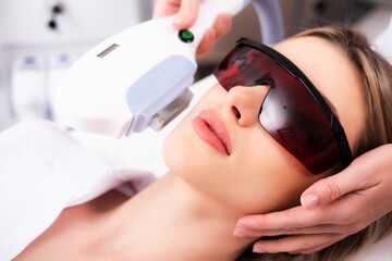 Laser hair removal on a woman's face in a beauty salon. Photo of a woman receiving a cosmetologist procedure for skin rejuvenation. The concept of aesthetic medicine. Modern technologies in medicine.