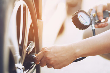 close up hand man car parking a check and inflate the tire fill up the air for safe driving on the...