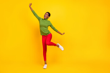 Fototapeta na wymiar Photo of pretty sweet trans woman wear green turtleneck dancing empty space isolated yellow color background