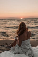 Fototapeta na wymiar girl sitting at sunset by the sea