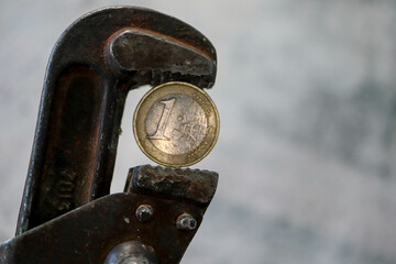 one euro coin in pincers - sanctions against russia from europe wallpaper