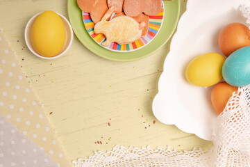 White empty list on Easter background with colored eggs and homemade cookies