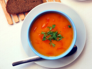 Vegetarian pumpkin soup in a bowl garnished with herbs. Isolated on white background. flat lay