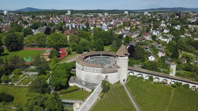 Aerial orbit of Munot ring-shaped fort on top of verdant hill in picturesque Schaffhausen village surrounded by trees, Switzerland