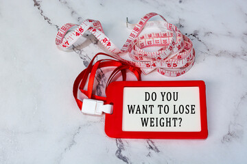 Do you want to lose weight text on a red name tag with measure tap on white desk