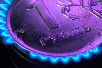 Russian 1 ruble coin is illuminated with magenta light. close-up. photomontage: burning coin.