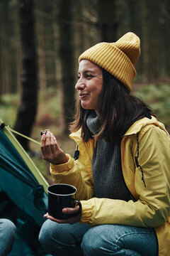 Smiling Woman Eating A Snack While Camping