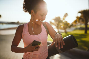 Sporty woman walking listening to music while walking to yoga - Powered by Adobe