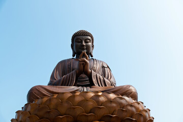 Wooden Buddha statue under blue sky