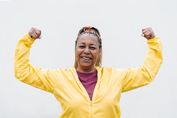 Naklejka premium Senior African woman doing exercise workout routine outdoor - Focus on face