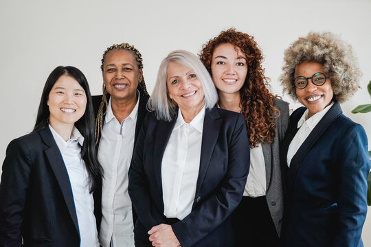 Multiracial business women smiling on camera inside bank office - Focus on African girl face