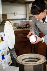 Ceramic Artisan putting ceramic items into kiln