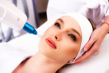 Facial carbon peeling procedure. Cleansing the skin with laser pulses at the beautician. The concept of hardware cosmetology. The process of photothermolysis, warming the skin.