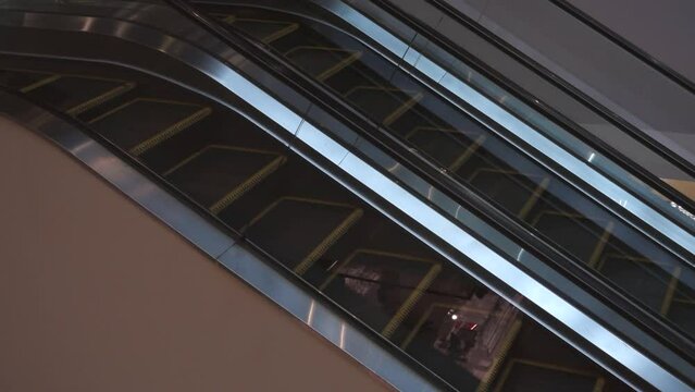 Empty steps of an escalator move up and down in a shopping mall.