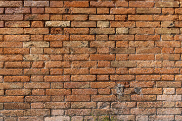 Red brick clay wall on a sunny summer day. Old wall texture, Italian architecture.