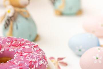 Easter donut, Close up of a piece of pink donut with colorful sprinkles, and Easter decor on white background