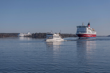 Obraz premium Cruise ferries from Finland and an archipelago commuting boat arriving a sunny spring day in Stockholm