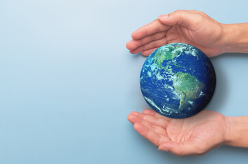 Hands holding earth globe on blue background, International human solidarity day concept, world...