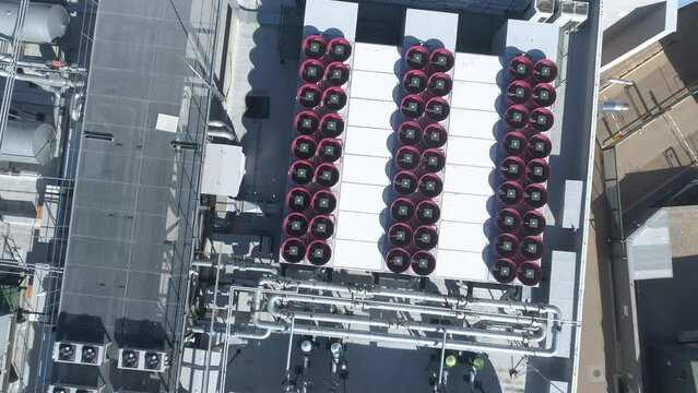 Aerial birdseye of HVAC cooling systems, fans, air conditioning on rooftop of modern data center building.
