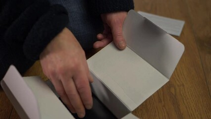 Hands opening mobile phone delivered in a box