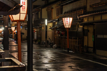 Japanese lanterns along quiet road in rain