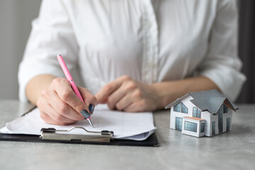 woman holding house model, tablet