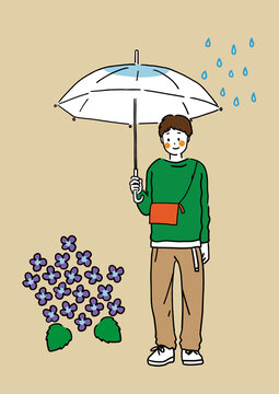 梅雨の季節に雨の中傘をさす若い男性