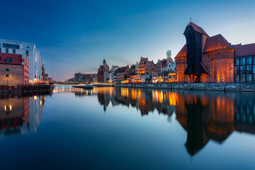 Historic port crane in Gdansk reflected in the Motlawa river at dusk, Poland