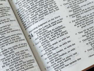 Obraz premium Judgment Day, the second coming of Jesus Christ. Open Holy Bible Book, Isaiah 24 prophecy. Christian biblical concept of justice and hope. A close-up.