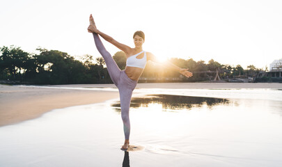 Flexible Caucaisan woman feeling balance and harmony during yoga practice doing asana yoga pose...