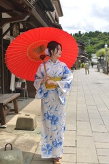 Fototapeta premium 小江戸佐原の町並みと和傘を持つ美しい浴衣姿の若い女性