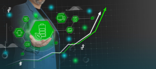 Businessman holding battery sign with green leaves - green energy concept. Eco renewable power for different devices - laptop, smartphone, computer. Development of nature friendly technologies