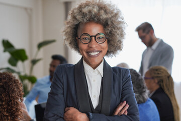 African business woman smiling on camera inside modern office