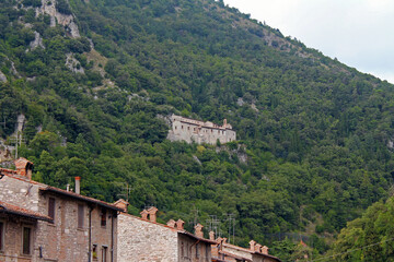 The traditional village on the cliff among the trees in Umbria