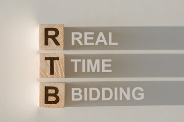 RTB - short for Real Time Bidding in wooden alphabet letters with text on shadows on light gray...