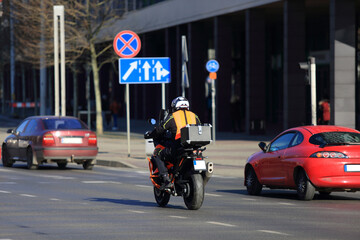 Fototapeta na wymiar Motocyklista z bagarznikiem jedzie ulicą Wrocławia. 